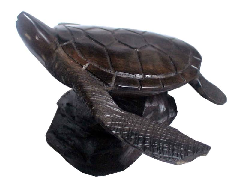 A carved wooden turtle sculpture on a base. A carved wooden turtle sculpture on a base.