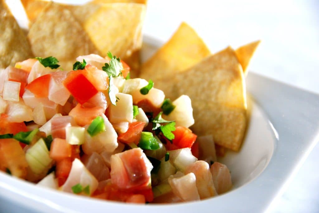 Ceviche - fresh fish and vegetables cooked in lime juice with a side of freshly fried corn tortilla chps