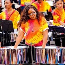 A woman playing steel drums