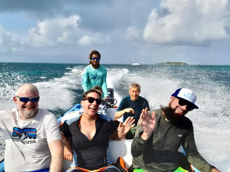 A smiling group of people enjoying a boat ride on the ocean A smiling group of people enjoying a boat ride on the ocean