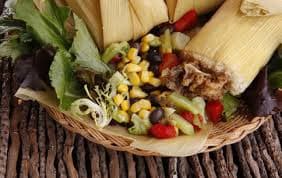 A plate of "dukunu" with tamales, and roasted corn and vegetables.